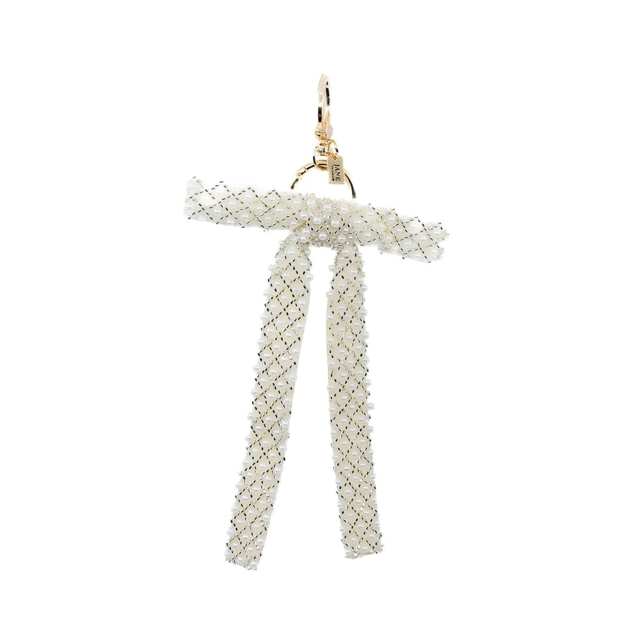 Embrace timeless elegance with this cream pearl beaded bow charm. Its intricate beadwork and soft hue add a touch of sophistication to your accessories. Perfect for elevating your bag and your outfit.