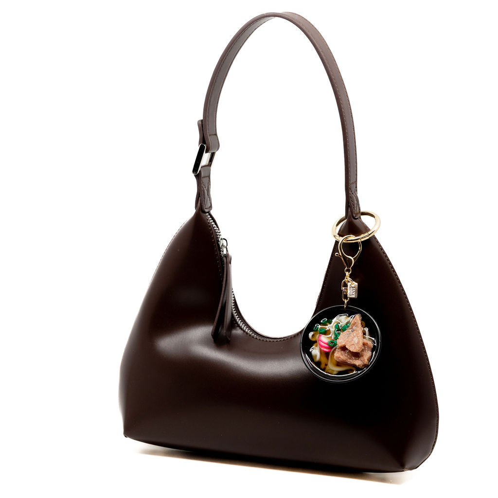 A steaming bowl of cozy for your purse. This playful charm features a hyper-detailed bowl of beef udon complete with noodles, sliced scallions, and pink narutomaki swirls.