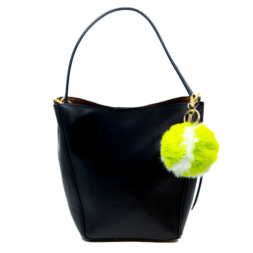 Black handbag with a green and white tennis pom-pom charm