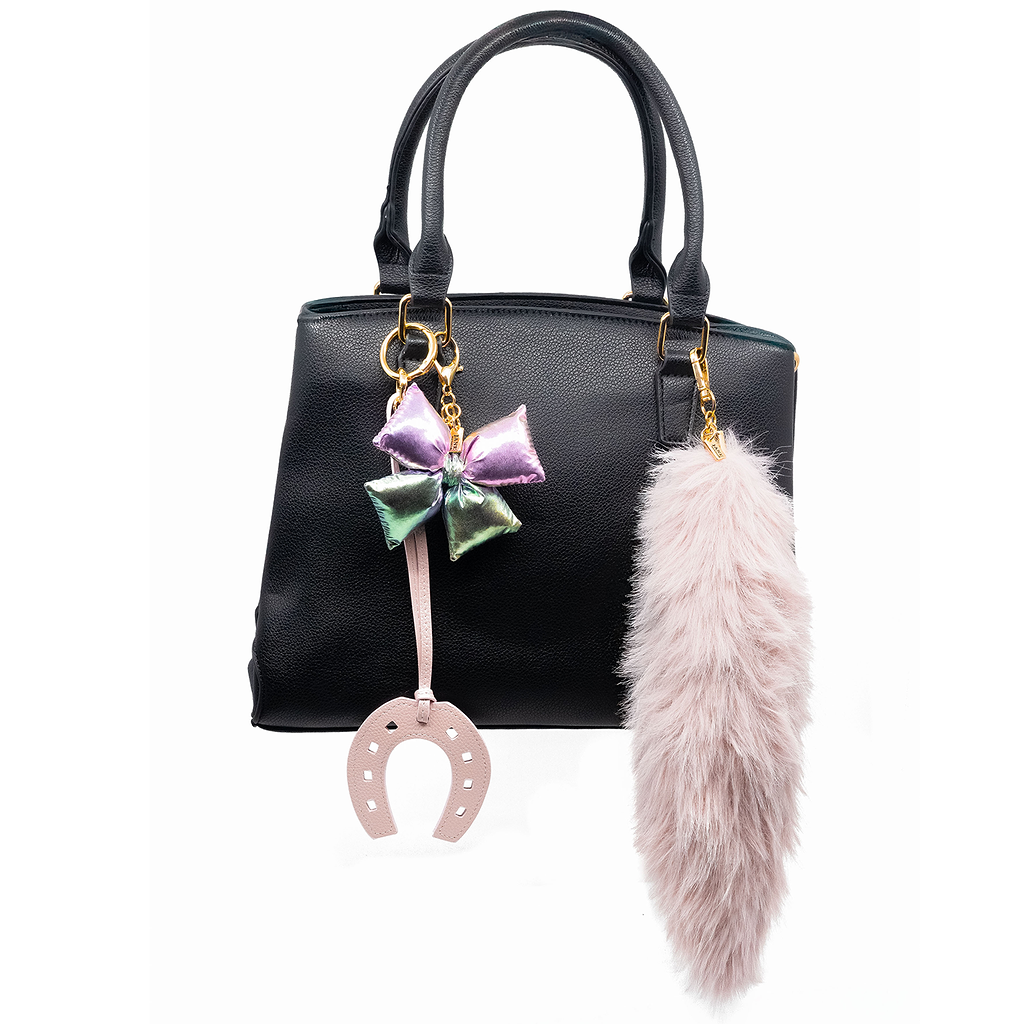 Add a playful pop to your accessories with this iridescent purple puffy bow charm. Its shimmering finish and charming design bring a whimsical flair, making it a delightful addition to your bag.