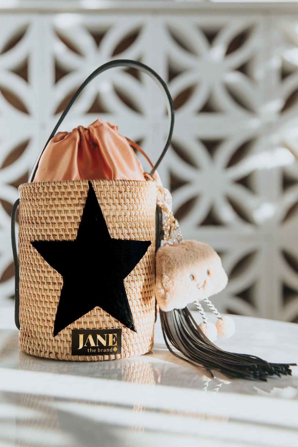 Woven bag with star design and 'JANE' purse charms.