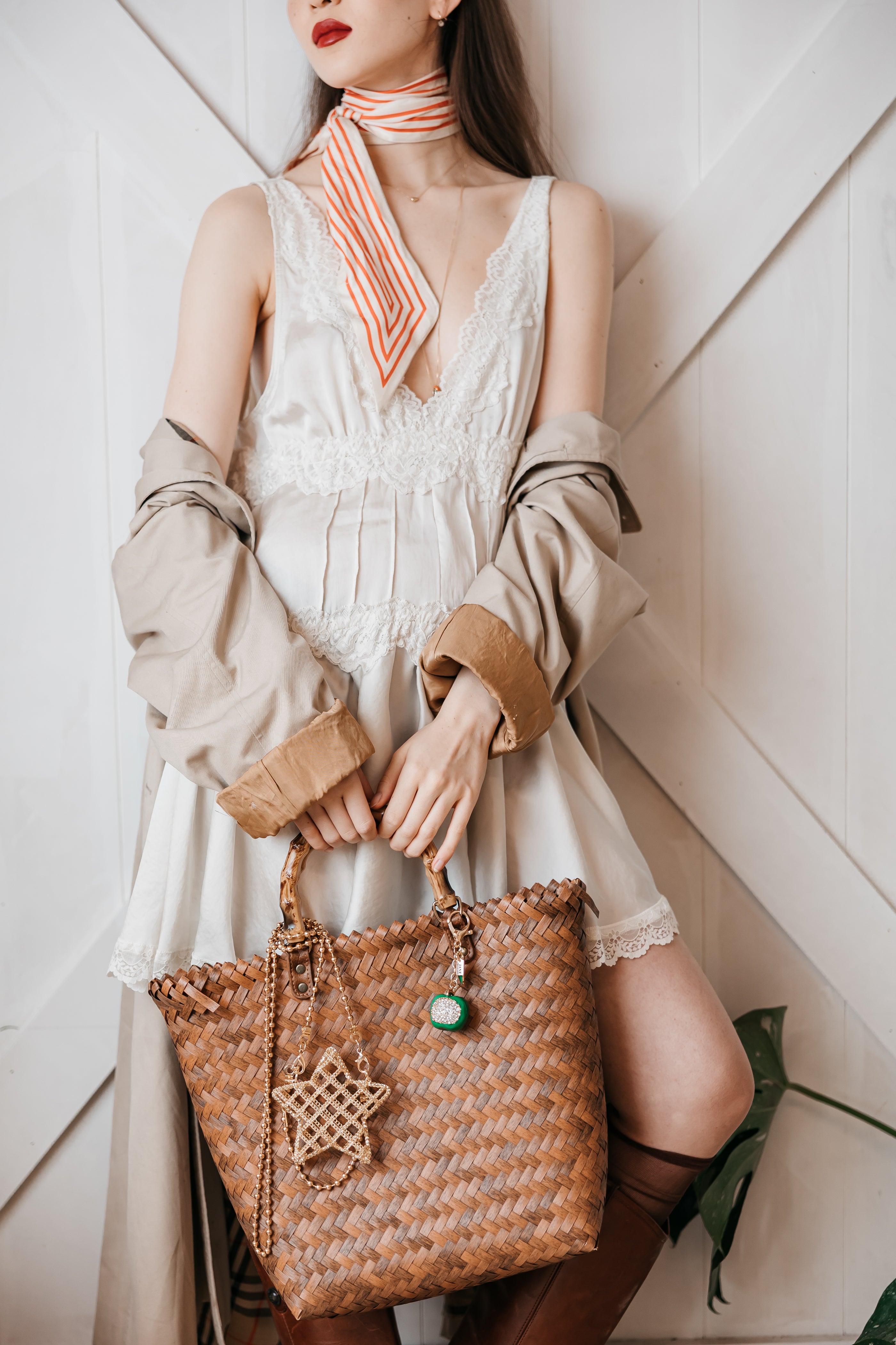 women holding a straw bag with charms
