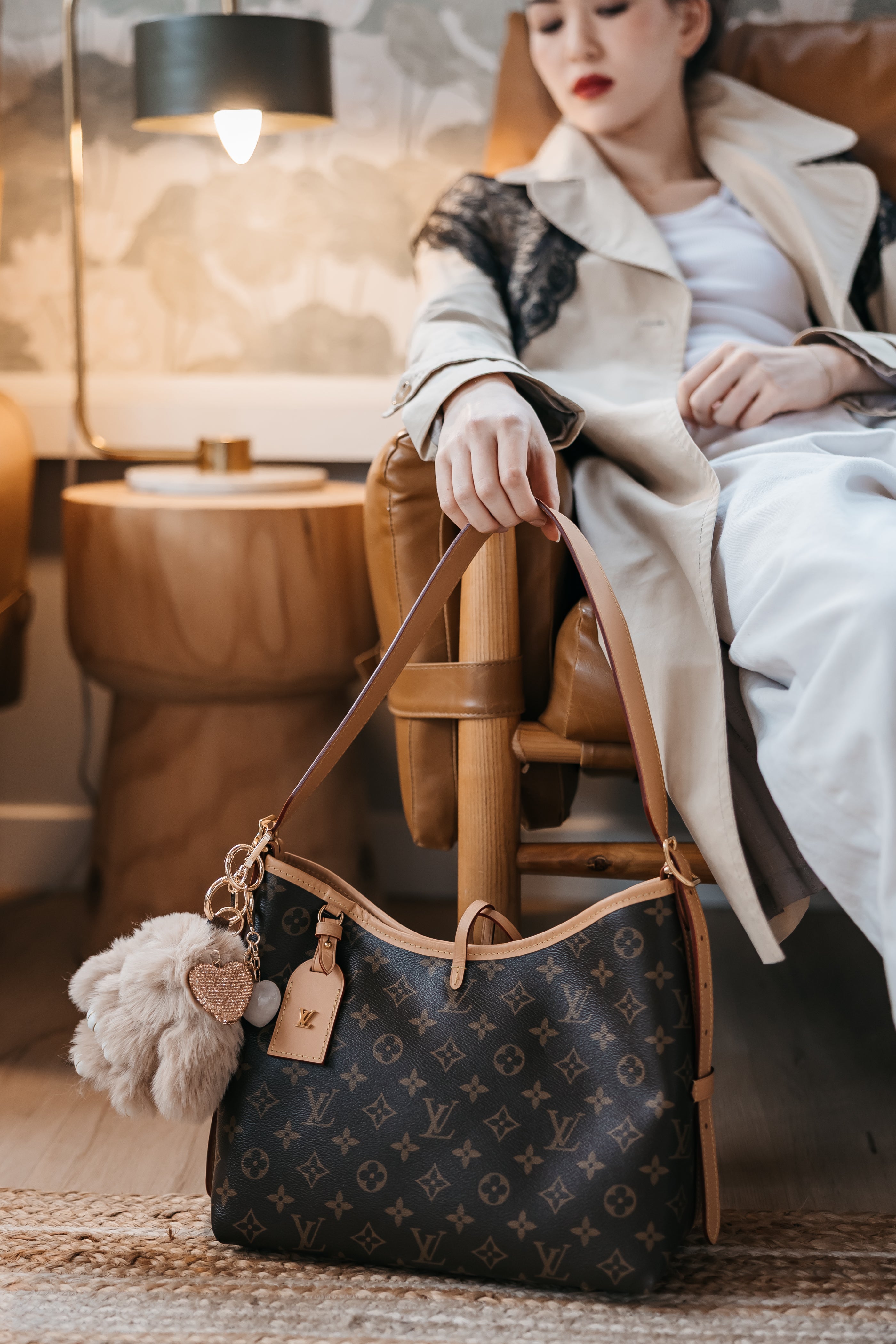 Woman holding a Louis Vuitton handbag in an indoor setting